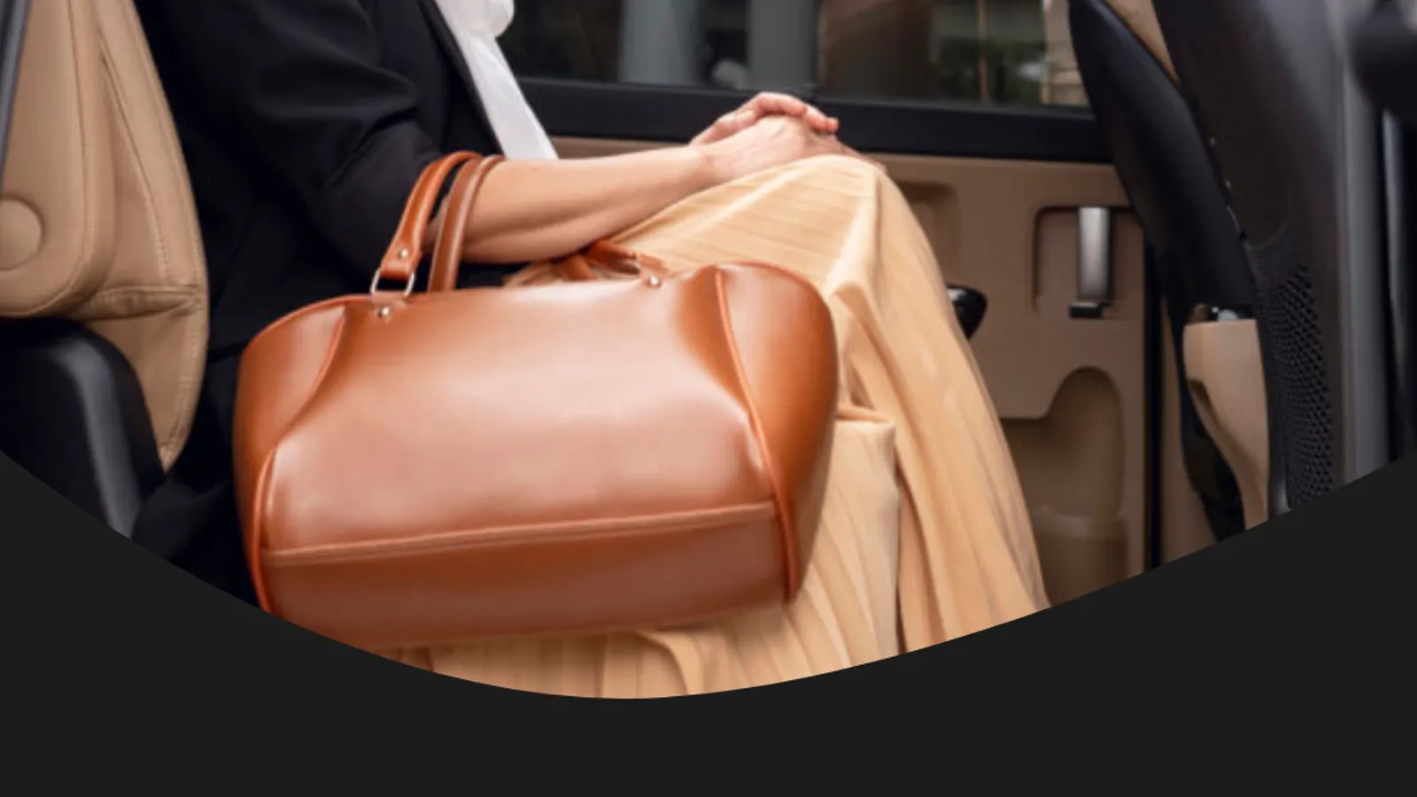 Rear cabin of a chauffeur driven car with a coat and bag on the seat