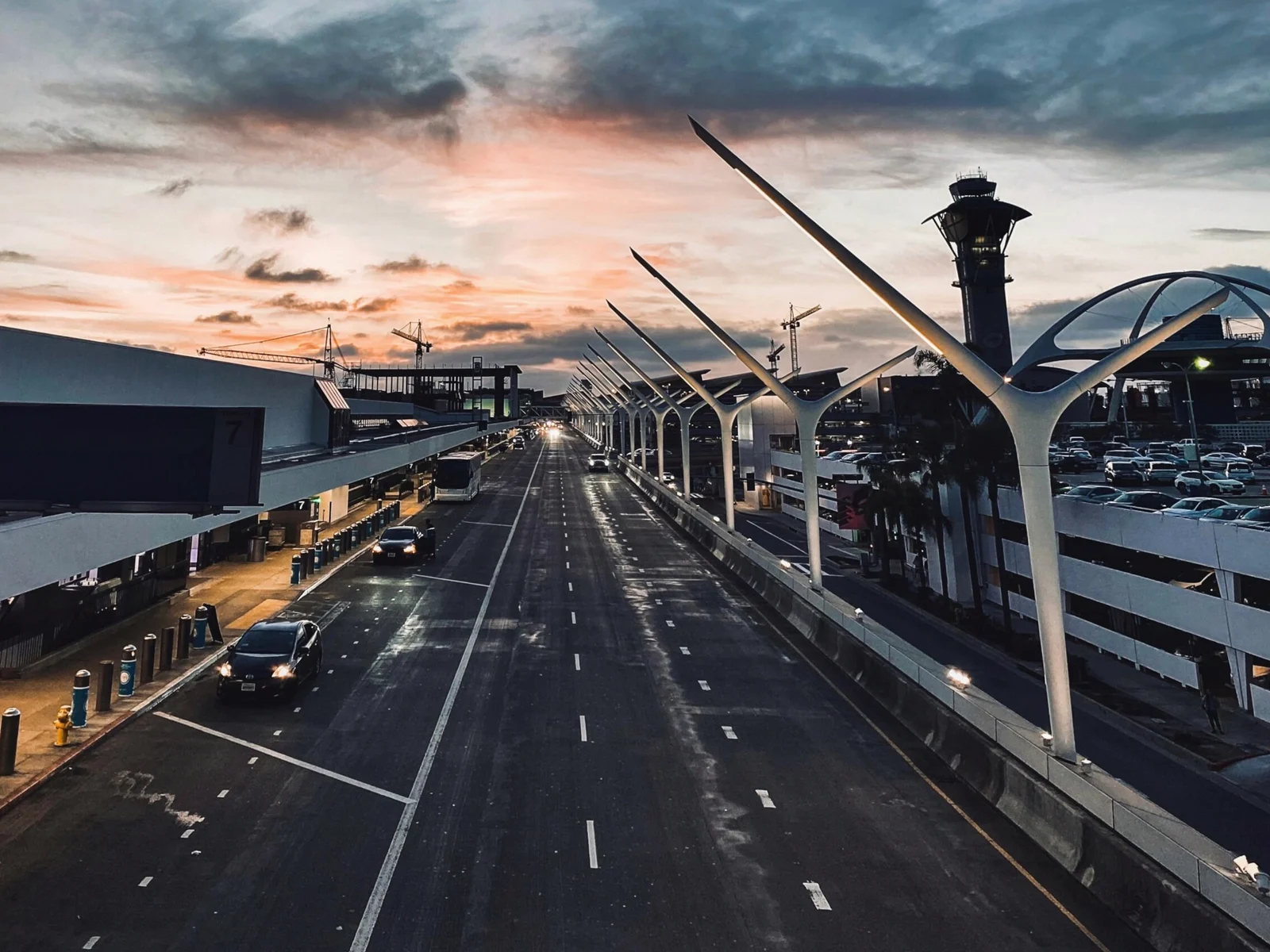 The departures level at Los Angeles International at dusk, with the pylons and the control tower