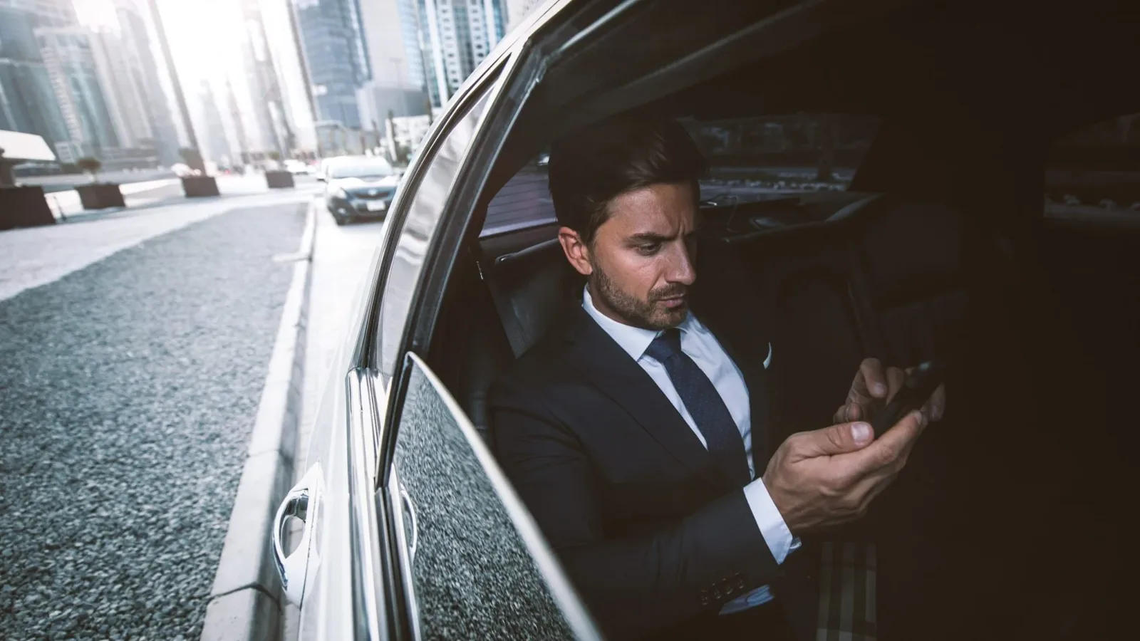Passenger working in the rear seat of a chauffeur driven car