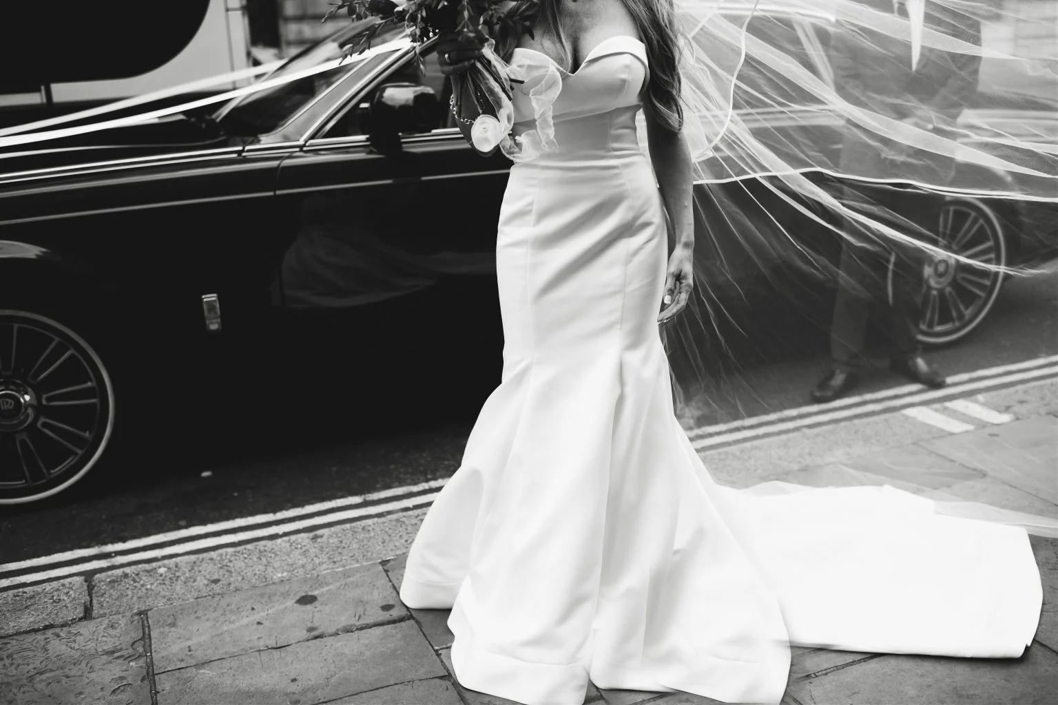 Wedding Car Service Los Angeles 1 A bride beside a black wedding car, veil in the wind